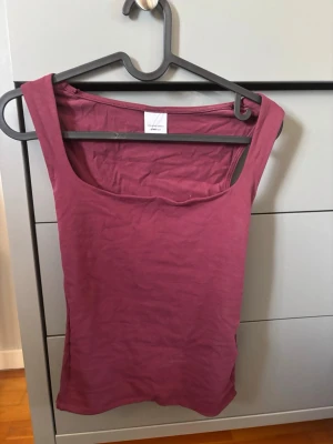 Mörkrosa linnetopp från H&M - En enkel och stilren mörkrosa linnetopp från Gina Tricot. Toppen är ärmlös med rundad halsringning och tillverkad i mjuk bomull, perfekt för varma dagar eller som lager under en skjorta.