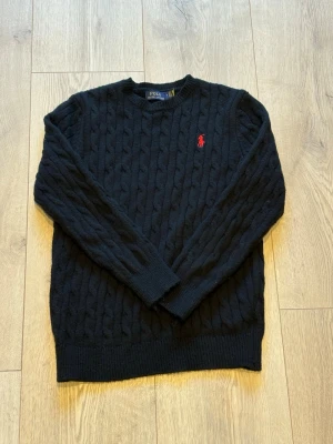 Kabelstickat Ralph Lauren - Kabelstickat svart från polo Ralph lauren. Helt ny bara använd 1 gång ny pris 2000kr. Lite för liten på mig 175cm 56kg hör av er om ni har funderingar.