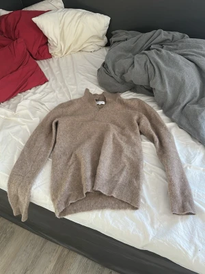 Beige stickad tröja från Davida - Mysig beige stickad tröja från Davida cashmere i storlek M. Tröjan har en avslappnad passform, v-ringad hals och långa ärmar. Tillverkad i mjukt material som känns lyxigt och skönt mot huden. Perfekt för lager på lager under kyliga dagar. OBS! Liten i storleken om du har small skulle denna tröjan passa dig, NYPRIS 2000kr