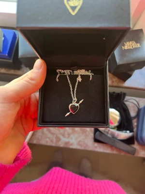 Maria Nilsdotter halsband Rebel love necklace  - Snyggt halsband från Maria Nilsdotter med en silverkedja och en hjärtformad röd sten. Halsbandet är knappt använt då jag ej gillar stilen och kedjan är i längden 50