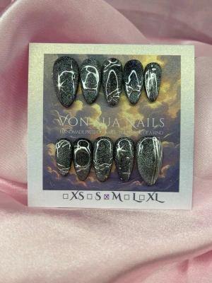 Stardust (M);Medium Almond - Handgjorda press-on naglar i svart med glittereffekt och silvriga 3D nailart. Naglarna har en medium almond form och cool cateye  som verkligen sticker ut. Perfekt för dig som vill ha unika och trendiga naglar utan att gå till salong.M: 16 mm, 12 mm, 12,5 mm, 11,5 mm, 10 mm