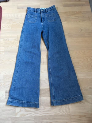 Jeans - Utsvängda jeans från &OtherStories i en mellanblå tvätt! Storlek 25, i fint skick och säljs då jag köpt en större storlek jag tycker passar mig bättre!!