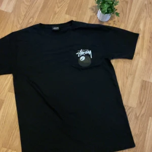 Svart Stüssy t-shirt med logga - Säljer en svart t-shirt från Stüssy med deras ikoniska logga tryckt på bröstet. Klassisk passform och rund halsringning. 