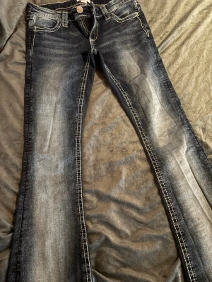 Mörkblå bootcut jeans från Ginatricot - Snygga mörkblå bootcut jeans från Ginatricot från 14+ i storlek s med slitningar och kontrastsömmar. Klassisk femficksmodell och dekorativ knapp framtill. Jeansen har en tvättad look och är tillverkade i bomull med lite stretch för skön passform. Passar mig som är 160, de är använt en gång💞 skriv vid frågor💞