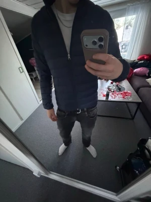 Mörkblå lättviktsdunjacka - Snygg mörkblå dunjacka med smal passform och quiltad design. Jackan har dragkedja framtill, ståkrage och långa ärmar. Perfekt för kalla vinterdagar och enkel att matcha med olika outfits.