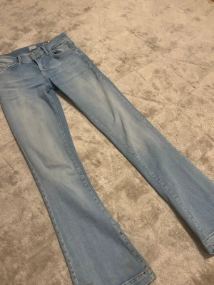 Ljusblå bootcut jeans från LTB - Säljer ett par ljusblå bootcut jeans från LTB Jeansen har klassisk femficksdesign, mid waist och är utsvängda Tillverkade i mjuk denim med snygga slitningar framtill och bakfickor med broderad detalj.☺️