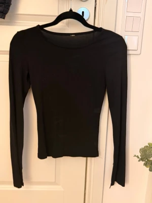Svart långärmad topp i bomull - En enkel och stilren svart långärmad topp med rund halsringning. Tillverkad i mjuk bomull som sitter skönt mot kroppen. Perfekt att matcha med jeans eller kjol för en clean look. Lappen är bortdragen pga av att den kliade men annars är tröjan i väldigt bra skick💖