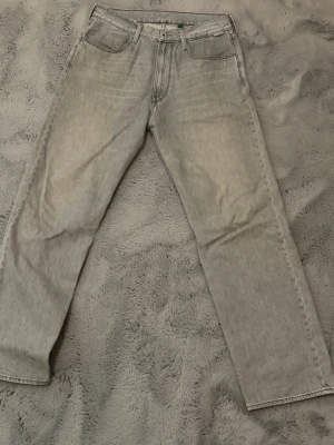 Grå Gstar Jeans - Säljer ett par grå Gstar jeans med rak passform och klassisk femficksdesign. Jeansen har en snygg tvättad vintage-look och är tillverkade i denim. Storlek 30/30 nypris 1400kr