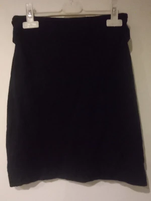 Svart kortkjol från Gina Tricot - En stilren svart kortkjol från Gina Tricot i mjukt tyg. Kjolen har en enkel och rak passform som är lätt att matcha med olika toppar och jackor. Perfekt för dig som gillar en klassisk look med modern känsla.