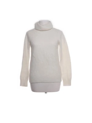 Vit polotröja i stickat material - Mysig vit stickad polotröja med lång ärm och hög krage. Tröjan har en klassisk rak passform och är perfekt för kyliga dagar. Materialet ser ut att vara mjukt och fluffigt, vilket ger en skön känsla.