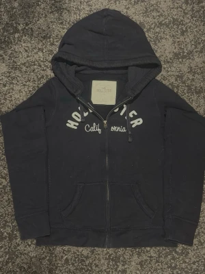 Mörkblå hoodie från Hollister - Säljer denna mörkblåa Hollister hoodie. Storlek Dam L och bra skick. Skicka ett meddelande om du har någon fråga. Bredd: 47 cm Langd: 56 cm