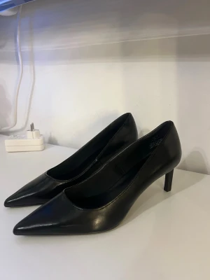 Svarta klackskor  - Ett par svarta låga klackskor med spetsig tå och smal klack. Storlek 38 i helt nytt skick! Från H&M 💞