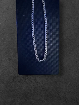 Kedjehalsband i silverfärg - Snyggt halsband med grov kedja i silverfärg. Halsbandet har en klassisk, tidlös design med rektangulära länkar som ger en cool och stilren look. Perfekt för att lyfta vilken outfit som helst och passar både till lager på lager eller som statement-piece.