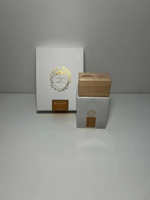 Giardini di Toscana Bianco Oro parfym - Elegant parfym från Giardini di Toscana i modellen Bianco Oro. Flaskan är vit med en stilren träkork och gulddetaljer. Kommer i en lyxig vit presentförpackning med guldfolierad logga och dekorativ design. Perfekt för dig som gillar exklusiva dofter.