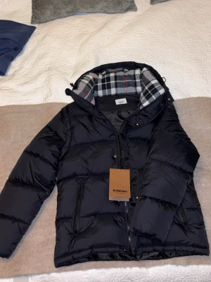 Svart pufferjacka från Burberry - Snygg svart Burberry jacka med armar som går att dra av. Perfekta för våren eller vintern. Aldrig använd