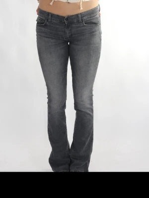 Grå bootcut jeans med låg midja - Snygga grå jeans med bootcut passform och låg midja. Jeansen har klassiska fem fickor och subtila slitningar för en avslappnad look. Perfekta till sneakers eller boots och passar till många olika stilar. Insydda själv