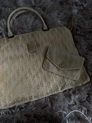 Beige datorväska från Dior - Från min gammelfarmor samling. Det har spillts kaffe eller något över den men färger säkert rengöra vissa saker för den som kan. Jätte vacker och en av det första dior väskorna som gjordes. Kan mötas vid pantbank eller liknannde. För att vara så gammal förutom fläckarna så e den i fint skick. Kom me bud 