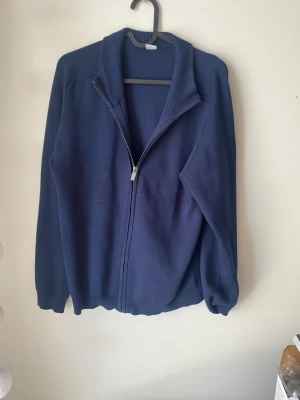 Mörkblå tröja från Lindex - En enkel och stilren mörkblå tröja från Lindex i storlek 170. Tröjan har rund halsringning, långa ärmar och ribbade muddar vid hals, ärmslut och nederkant. Perfekt för en clean och avslappnad 