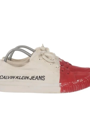 Calvin Klein Jeans vita/röda sneakers - Unika sneakers från Calvin Klein Jeans i vitt tyg med röd tå och sula. Skorna har snörning, låg profil och tydlig logga på sidan. Den röda färgen täcker främre delen och ger en cool kontrast till resten av skon. Perfekta för dig som vill sticka ut med din stil.