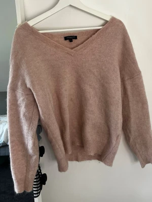 Ljusrosa stickad tröja Selected Femme - Mysig ljusrosa stickad tröja från Selected Femme med v-ringning. I bra skick men har en liten mascara fläck på ena armen därav sänkt pris!