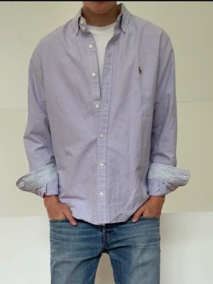 Randig Blå Ralph Lauren skjorta  - Blå Ralph Lauren skjorta med randiga ärmslut i mycket bra skick! Strl L men sitter som en M och hör gärna av er vid frågor elr funderingar!!