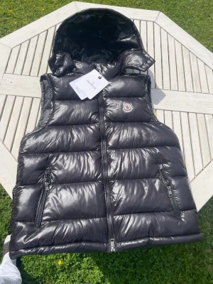 Svart moncler väst - Fick västen i present men den passar inte mig så därför jag säljer den. Väldigt fint skick inte alls använd bara testad