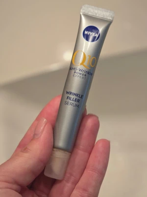 Nivea Q10 Wrinkle Filler Serum - Nivea Q10 Anti-Wrinkle Power Expert Wrinkle Filler Serum i en smidig silverfärgad tub på 15 ml. Perfekt för att reducera fina linjer och ge huden extra lyster. Tuben är lätt att använda och passar bra i necessären. Den är använd ett fåtal gånger. Ord. Pris 199kr