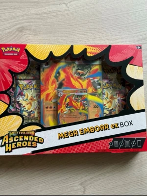 Pokémon Ascended Heroes Mega Emboar ex Box  - Pokémon Ascended Heroes Mega Emboar ex Box från serien Mega Evolution. Helt ny och i originalskick (Factory Sealed). 4x Sealed Ascended Heroes Booster Packs, 1x Mega Emboar Ex foil-promokort, 1x Mega Emboar Ex i storskaligt kort (3D-effekt). Skicket är det som syns på bilderna.