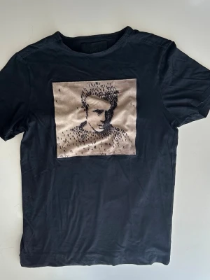 Limitato T-shirt Svart - Limitato svart T-shirt med konstnärligt grafiskt tryck framtill. Tillverkad i Portugal av 100 % merceriserad bomull. I fint begagnat skick med normala tecken på användning. Inga hål, fläckar eller större defekter.  Storlek S. Mått framgår av bilderna.  Nypris: ca 1 500 kr Pris: 299 kr