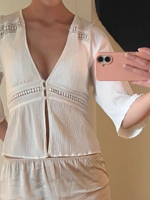 Vit topp/blus - Väldigt söt vit topp/blus från Zara i storlek S. Använd men i bra skick, den knappen i mitten är lite uttöjd men inte sönder🫶