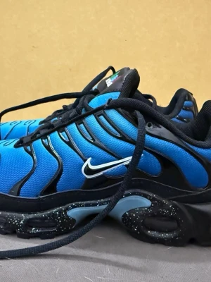 Nike air max plus Tn - Nike Air Max Plus Tn sneakers i blått och svart med vita detaljer och ikonisk Swoosh-logga på sidan. Ovandel i mesh och syntet, svarta snören och specklad mellansula. Skön dämpning och sportig vibe, perfekt för dig som gillar streetwear.