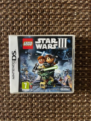 LEGO Star Wars III The Clone Wars DS - Nintendo DS-spelet LEGO Star Wars III: The Clone Wars är ett actionäventyr där du spelar som LEGO-versioner av Star Wars-karaktärer. Omslaget är färgglatt med figurer som Yoda och Anakin, och spelet är utvecklat av LucasArts. Perfekt för dig som gillar Star Wars och LEGO.