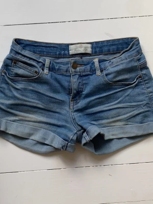 jeansshorts - Säljer ett par klassiska blå denimshorts från Globe med upprullade benslut och femficksmodell. Shortsen har normal passform och är perfekta för varma dagar. Stängs med knapp, tyvärr är knappen då sönder men de går att använda precis som vanligt ändå! Inga andra defekter än så, skriv för frågor💕