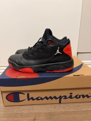 Skor från Jordan - Snygga svarta Air Jordan sneakers med röda detaljer och vit Jumpman-logga på sidan och plösen. Skorna har en hög siluett, svarta skosnören och meshpaneler för extra ventilation. Perfekta för dig som gillar streetwear och basketinspirerad stil.