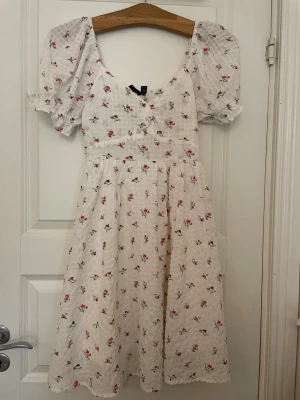 Blommig klänning  - Sommarklänning med rosa blommor i luftigt material. Endast använd fåtal gånger och i fint skick.