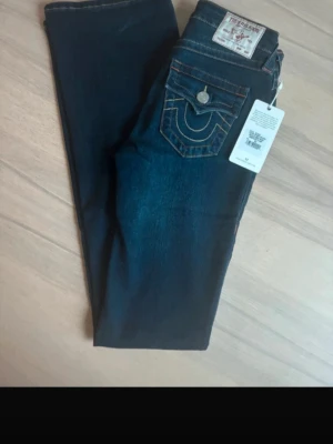 True religion jeans  - Säljer par true religion yjeans!  De e är endast testade en gång av förra ägaren som sedan sålde de på vinted till mig. De var tyvärr för små för mig med så säljer vidare de. De är köpta för orginalpris på True Religion.  👖 Modellen BECCA Mid Rise och färg är muddy waters. De är i storlek w24 vet inte riktigt vad det motsvarar.  Pris går självklart att diskutera!