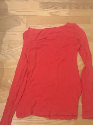 Intimissimi långärmad  - Intimissimi lpngärmad korall färgad tröja.En enkel långärmad topp med rund hals. Tunn och mjuk i materialet, perfekt att styla lager på lager eller bära som den är. Passar till många olika outfits och är ett måste i basgarderoben.