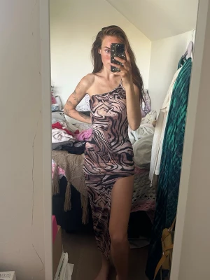 Mönstrad oneshoulder långklänning - Säljer en unik långklänning med asymmetrisk one shoulder-design och hög slits. Använd en gång till en photoshoot