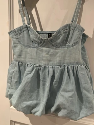 Jeans topp - H&M Divided XXS ljusblå jeans topp populär och slutsåld i butik. Ställbara axelband. Dragkedja i sidan.  Lappen kvar