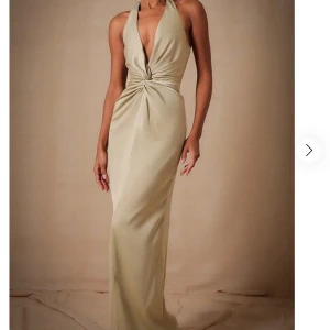 Maxiklänning - Slutsåld ”Sage Bridesmaid Satin Twist Plunge Halterneck Maxi Dress” från PrettyLittleThing.  