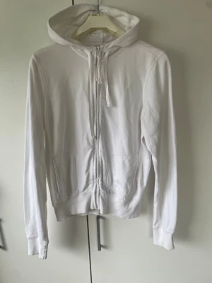 Vit hoodie  - Säljer en klassisk vit hoodie med dragkedja och huva. hoodien är i storlek xl men själv bär jag s-xs och passa mig perfekt utan att vara hängig eller overs size.