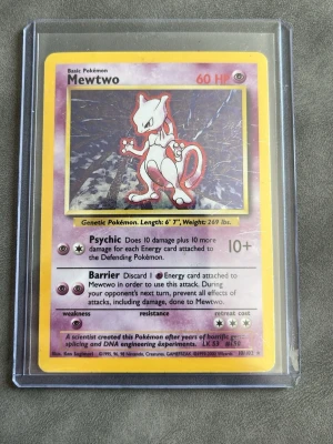 Mewtwo Pokémonkort Base Set - Säljer ett klassiskt Mewtwo Pokémonkort från Base Set, original från 1999. Kortet har lila och gul ram, och är skyddat i en plastficka. Perfekt för samlare eller Pokémonfans som vill ha en ikonisk figur i sin samling.