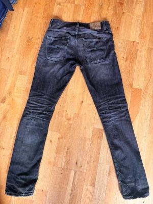Svarta selvage nudie jeans - Jag säljer ett par riktigt snygga selvage jeans från Nudie med snygga honeycombs på baksidan och en unik färgkombination. Jeansen är i storlek w30 l34. Det är bara skriva om det finns fler frågor!