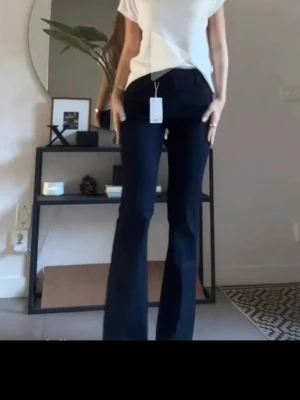 Mörkblå bootcut jeans - Säljer ett par mörkblå bootcut jeans med mid waist midja och utsvängda ben. Klassisk femficksmodell i stretchigt denimtyg som sitter snyggt och bekvämt. 