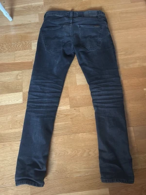 Nudie jeans - Säljer ett par feta svarta nudies. Storlek W27 L30. Modell grim tim. Priset är inte ristat i sten