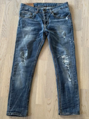 Dondup jeans - Säljer dessa tvär feta dondup jeans med slitningar | Modell: George | Storlek 32 | Bra skick, slitningar är design | Jeansen saknar medall D:et på bakfickan | Hör av dig vid minsta fråga eller fundering 