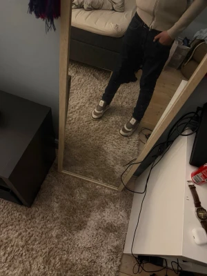 Nike Dunk Low grå/vita sneakers - Säljer ett par Nike Dunk Low sneakers i grått och vitt. Klassisk siluett med lågt skaft, vit sula och grå detaljer. Ikonisk Swoosh på sidan och snörning framtill. Perfekta för dig som gillar streetwear och vill ha en clean look.