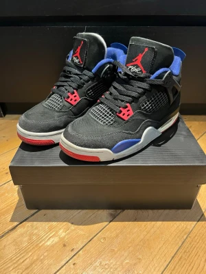 Air Jordan 4 Retro OG (Rare Air)  Black/Red/Blue - Säljer ett par Nike Air Jordan 4 retro Rare Air  i snygg färgkombination.  * Storlek: EU 38,5 * Färg: Svart med röda & blå detaljer * Skick: Använda men i bra skick (se bilder) * Klassisk modell som alltid håller värdet  Perfekta för både streetwear och vardag 🔥  📦 Snabb frakt 💬 Kan skicka fler bilder vid behov