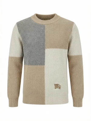 Patchwork stickad tröja från Burberry - Säljer en stickad tröja från Burberry med cool patchwork-design i beige, grått och vitt. Tröjan har rund hals och ribbstickade muddar. Materialet är tjockt och mjukt, perfekt för att hålla dig varm. Burberry-loggan är broderad på framsidan.