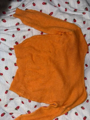 Orange stickad tröja i mohairmix - Säljer en orange stickad tröja i storlek XS, tillverkad av 50% mohair och 50% akryl. Tröjan har en enkel och klassisk design med långa ärmar och är perfekt för att ge din outfit en färgboost. Supermjuk och lätt, passar dig som gillar att sticka ut.